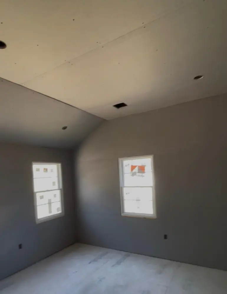 Bedroom with drywall hung on walls and ceiling